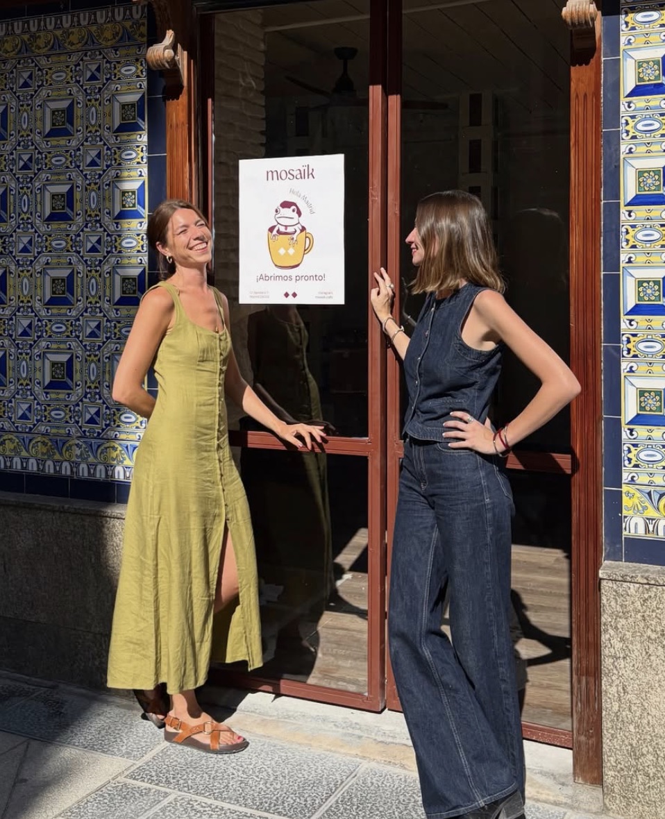 Prisca y Victoria, sonrientes, delante de la fachada de azulejos de Mosaïk Café
